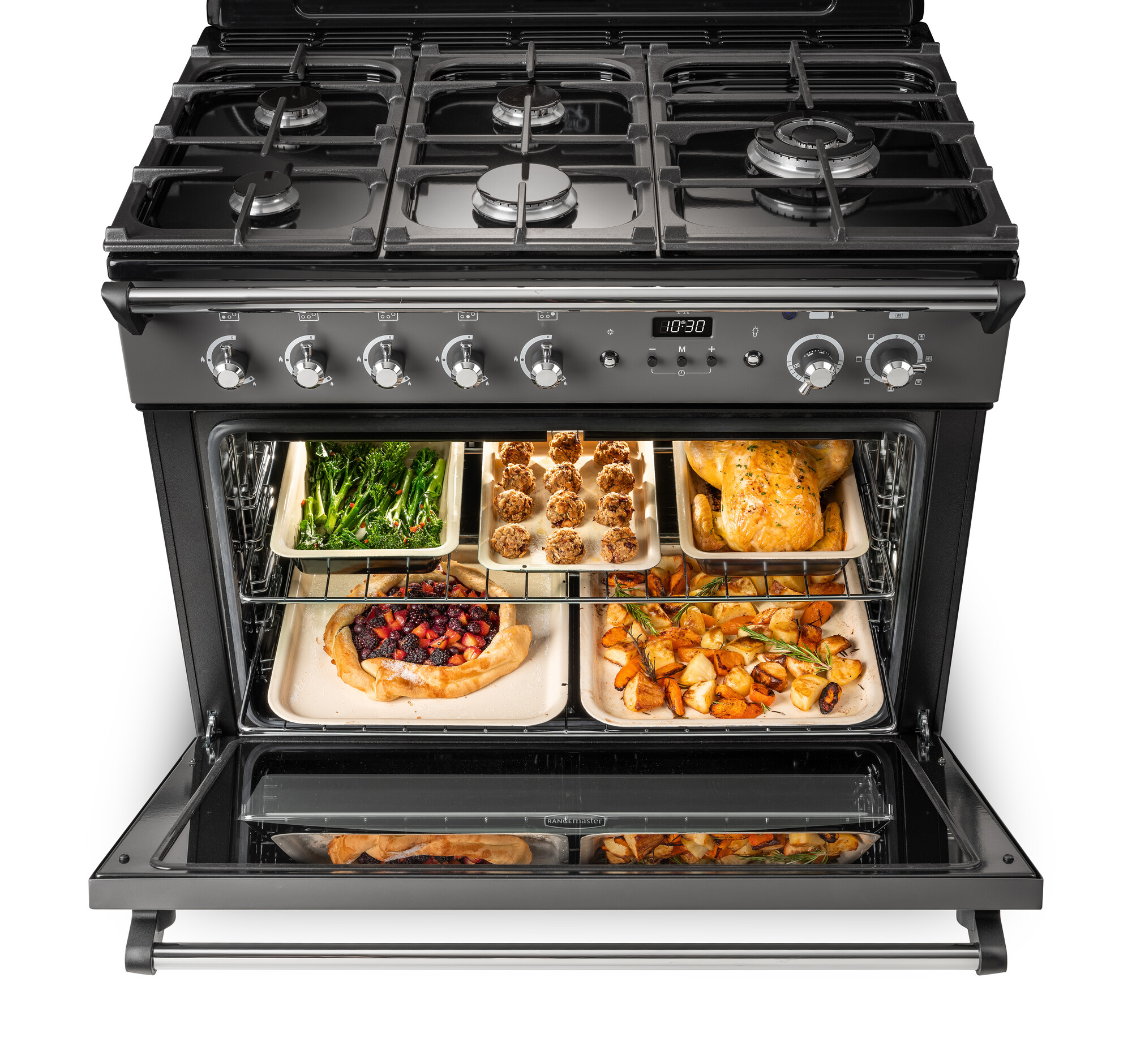 Geöffneter Backofen mit mehreren Backblechen, belegt mit frischem Gemüse, gefüllten Speisen, Brathähnchen, Kuchen und Ofenkartoffeln, Herd mit Gasfeldern oben